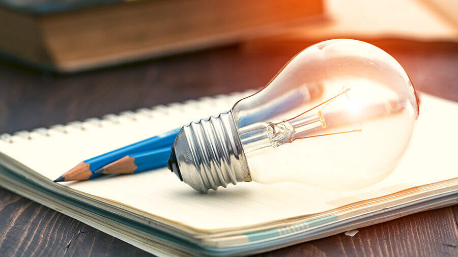 pencils and a lightbulb representing client onboarding ideas