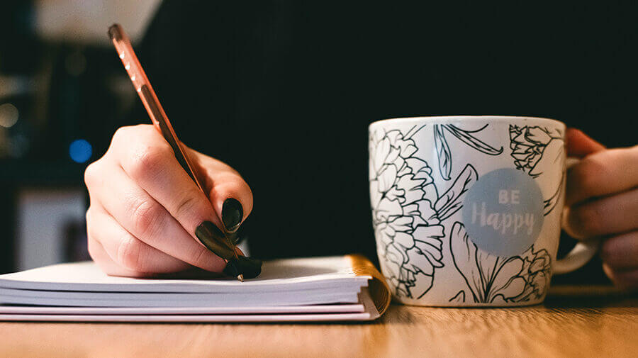 Woman writing productivity habits in journal