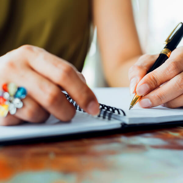 Woman mapping out a website content strategy in a notebook