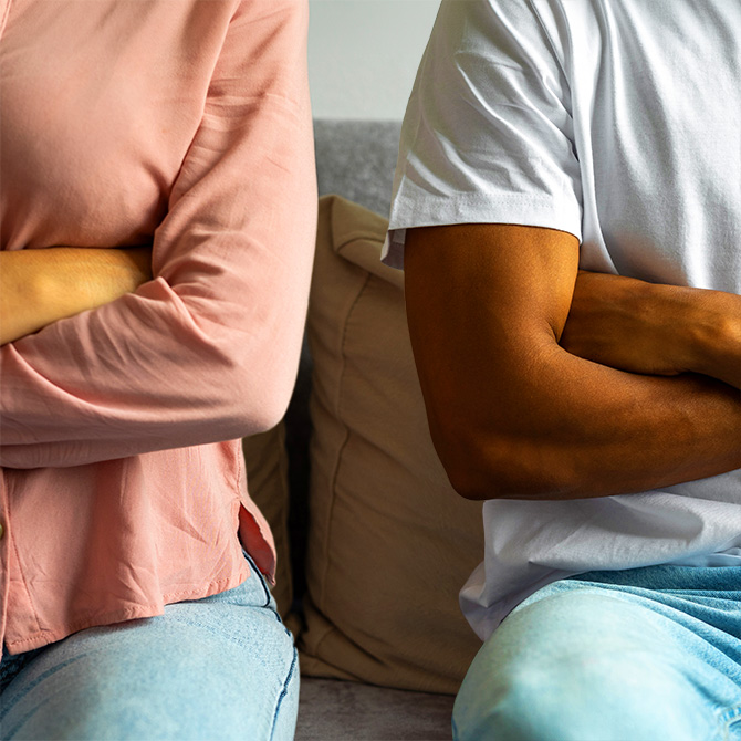 Two people, a man and a woman, a client and an expert service provider, both sitting with their arms crossed, feeling angry