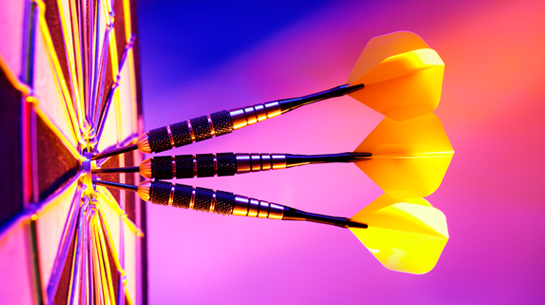Three bright yellow darts all stuck in the bullseye center of a yellow and pink dartboard — a smart brand strategy