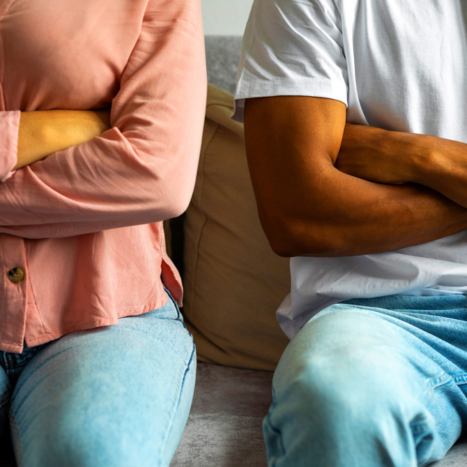 Two people, a man and a woman, a client and an expert service provider, both sitting with their arms crossed, feeling angry