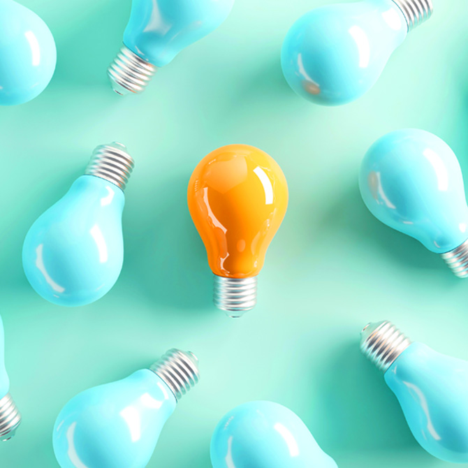 A solid yellow light bulb surrounded by aqua light bulbs on an aqua background and standing out as a new brand idea