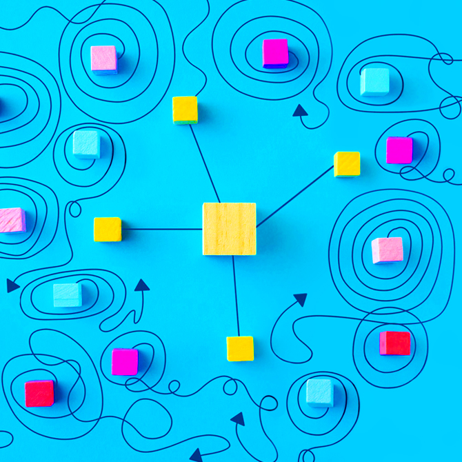 Yellow blue and pink square cubes representing brand ideas scattered on a blue background with messy lines connecting them and flowing in circles. One larger yellow cube sits in the center, connected to four other yellow cubes, representing the initial brand and clear directions