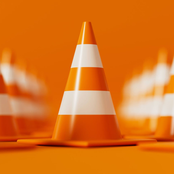 An orange traffic cone with white stripes in the center of rows of traffic cones to illustrate caution and doing your due diligence